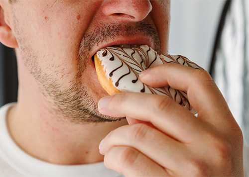 Close up of man face a eating donut.