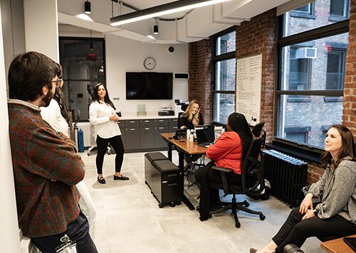 Crossover providers in a care team meeting in the bullpen.