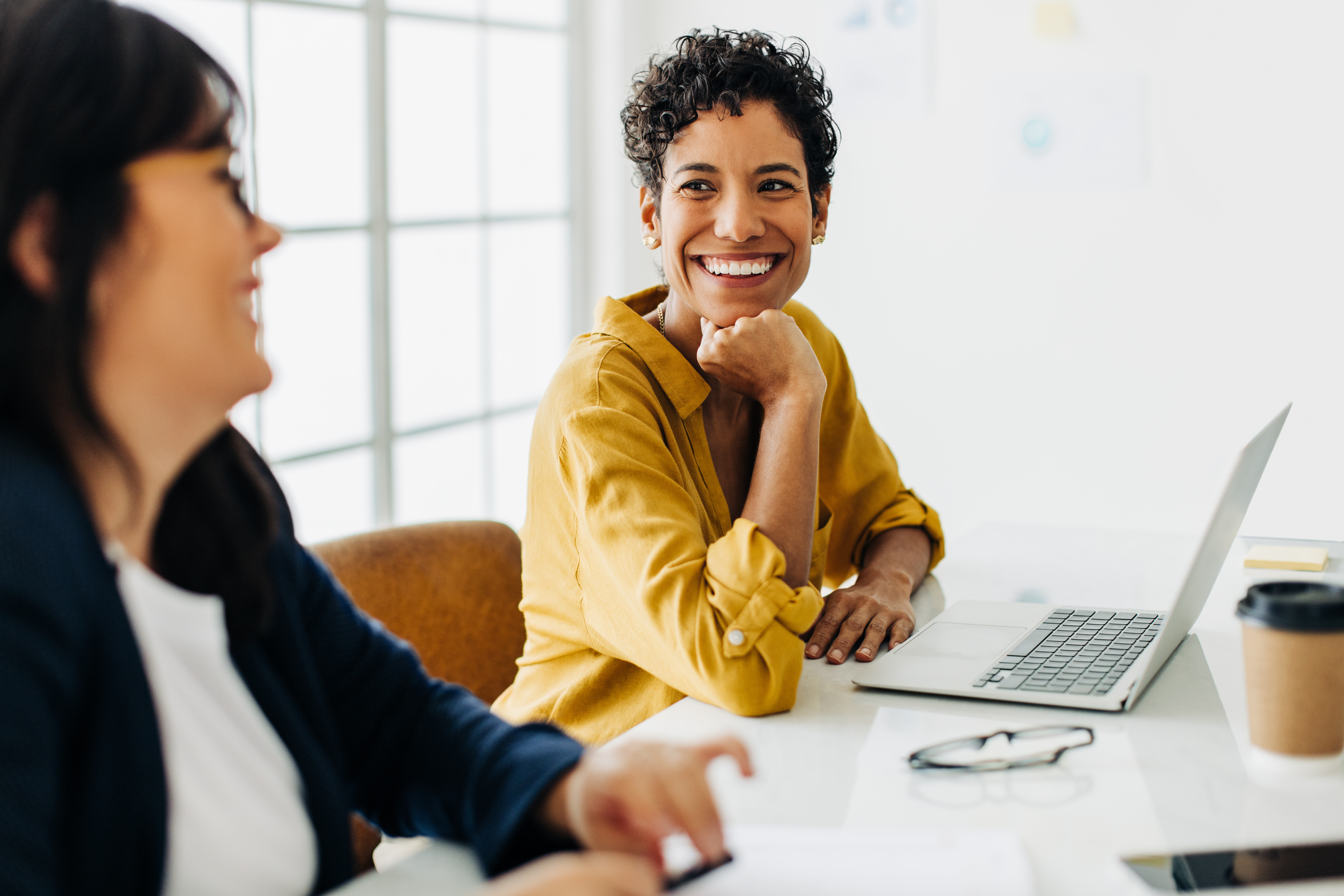 Happy business woman talking to her colleague in a boardroom.